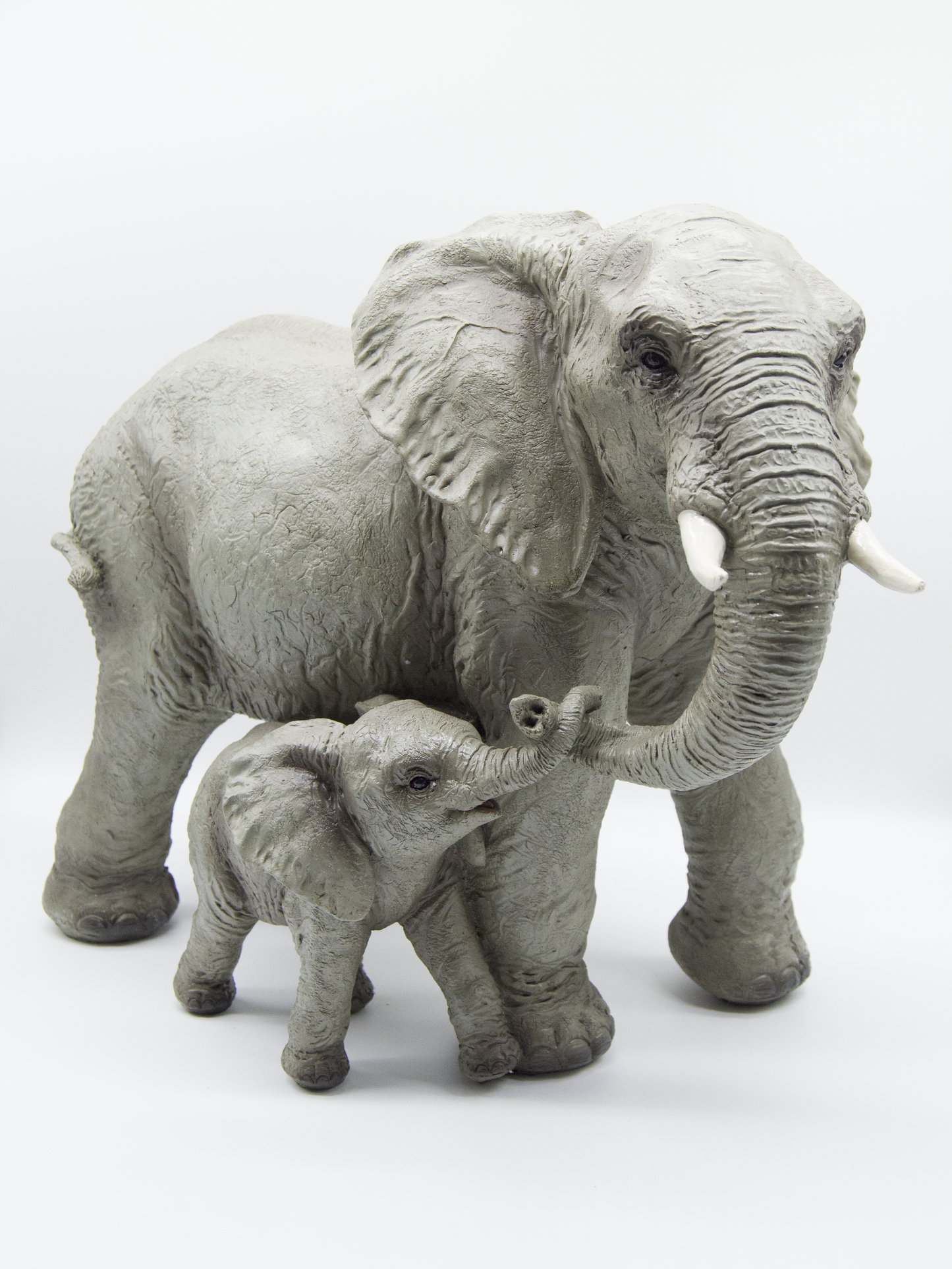 Elephant With Baby Holding Trunk